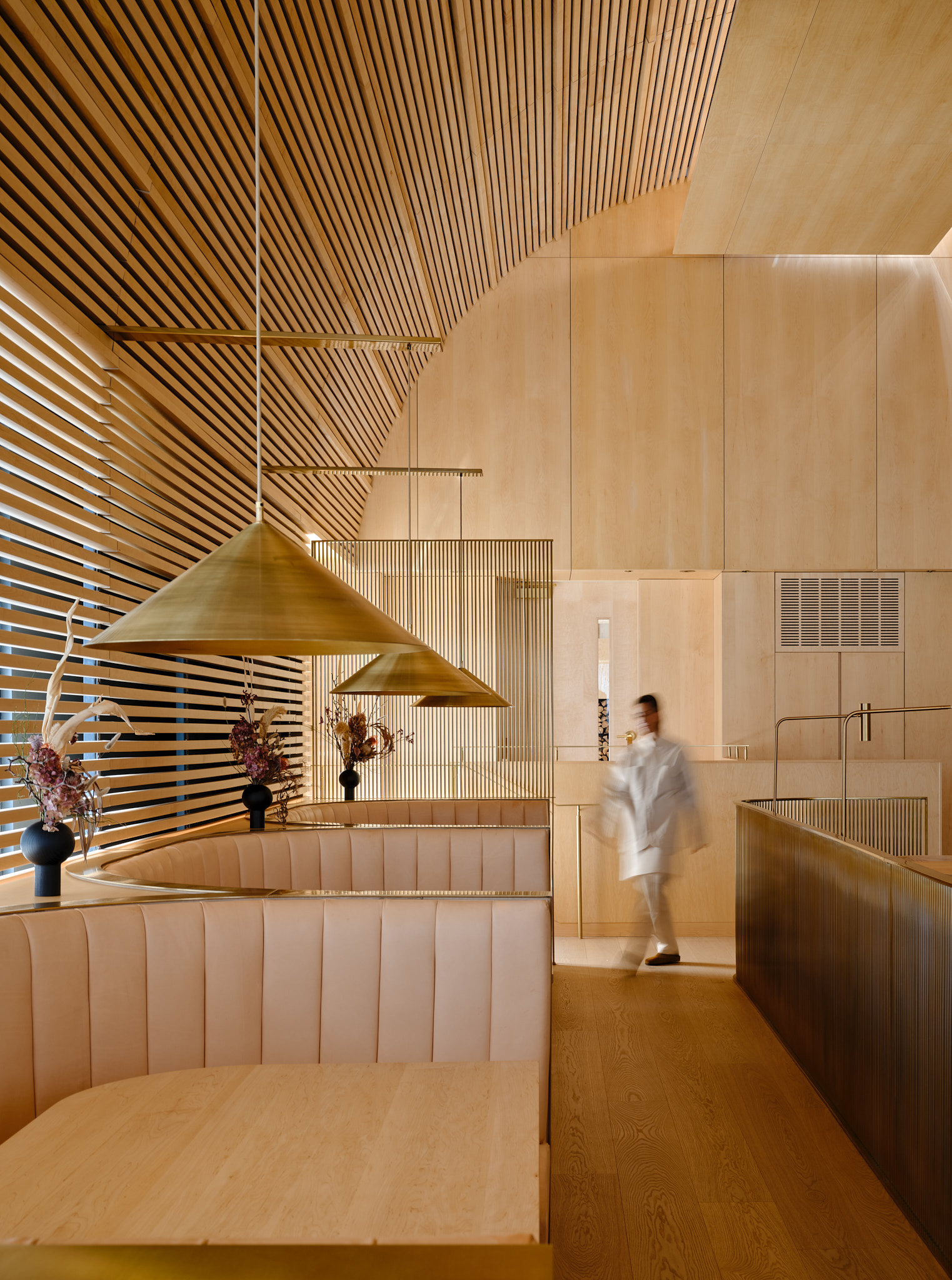Interior of Prime Seafood Palace in Toronto, designed by Omar Gandhi Architects, featuring wood booths and precise lighting.